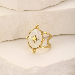 Macro detail of vintage gold oval mother-of-pearl ring with star inlay on stone surface