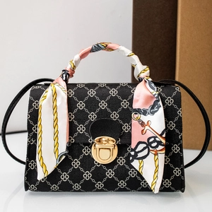 Elegante borsa a mano nera con motivi geometrici e dettaglio foulard di seta sul manico