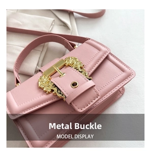 Close-up of pink leather handbag featuring a vintage golden lion head metal clasp detail