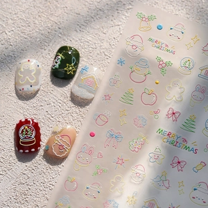Christmas nail stickers with 3D embossed Santa and reindeer designs on snowy white background