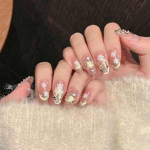 Winter press-on nails with nude gold cat-eye effect, white snowflakes and pearls