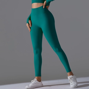 Detail of high-waisted seamless teal yoga pants with compression fit and thumb hole sleeves