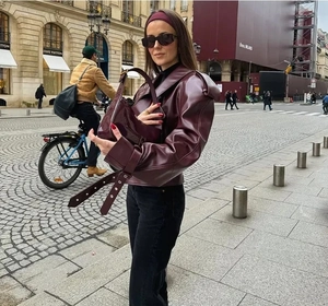 Detail of burgundy leather jacket with collar and matching shoulder straps in street setting