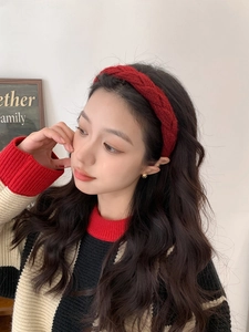 Detailed view of red knitted cable pattern headband on model with vintage aesthetic