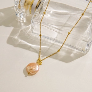 Gold-plated titanium steel necklace featuring pink baroque pearl and starburst pendant