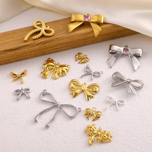 Polished gold and silver bow pendants for DIY jewelry making on silk fabric