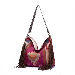 Detail of colorful bohemian woven hobo bag with deep brown fringes and braided strap