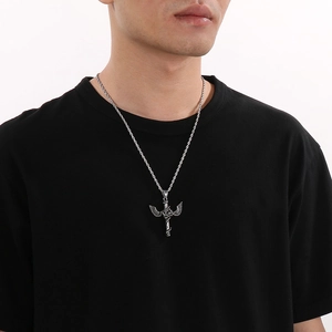 Close-up of gothic silver winged sword pendant with rose detailing on a man's neck