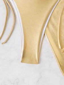 Detailed close-up of light gold metallic bikini bottom with shimmering pearl texture