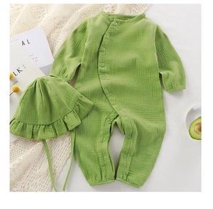 Detail of baby cotton gauze romper set with ruffled hat and snap buttons in green