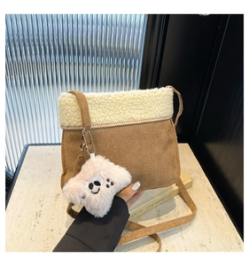 Détail d'un sac bandoulière en velours côtelé marron avec bordure sherpa et charm en peluche