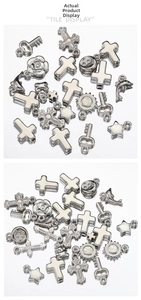 Macro detail of various Y2K silver metal charms including crosses, stars and hearts