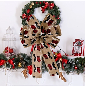 Close-up of rustic Christmas linen bow with festive motifs on a holiday wreath