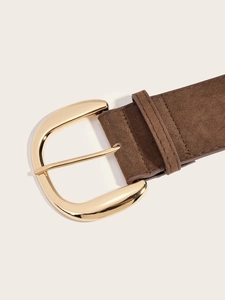 Macro shot of brown suede belt featuring a polished golden D-ring metal buckle