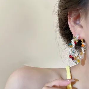 Gros plan d'un mannequin portant des créoles colorées avec perles et cristaux
