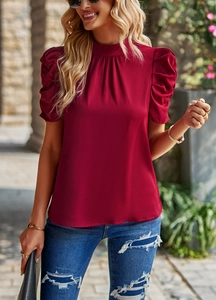 Close-up of deep red satin blouse featuring puffy short sleeves and elegant crew neck