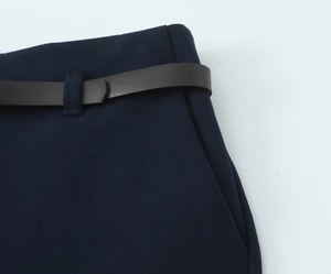 Gros plan du pantalon décontracté bleu marine avec un détail de ceinture fine marron