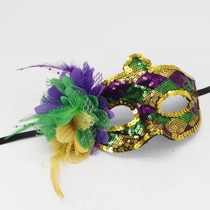 Detail of masquerade mask featuring purple green and gold feathers with sequin accents
