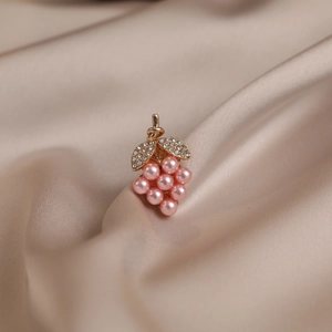 Pink pearl grape brooch with crystal leaves on champagne silk background