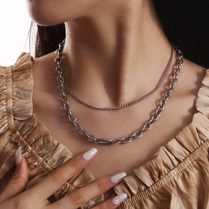 Close-up of double layered silver stainless steel necklace on a female model