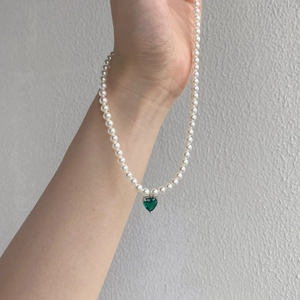 Detail view of S925 silver necklace with white pearls and a green heart gemstone pendant