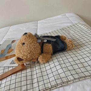 Cute plush puppy crossbody bag with denim vest and adjustable brown strap on checkered cloth