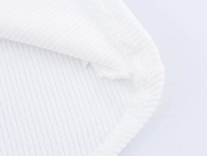 Macro view of white knitted ribbed fabric showing double-needle hem stitching quality