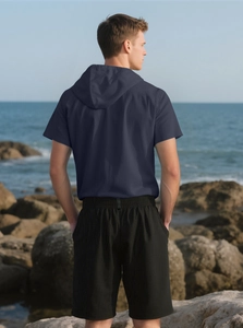 Men's navy hooded t-shirt and shorts set shown from back against beach scenery