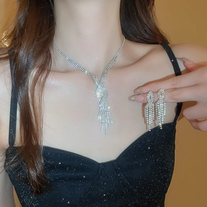 Close-up of sparkling rhinestone tassel necklace and earrings set on female model