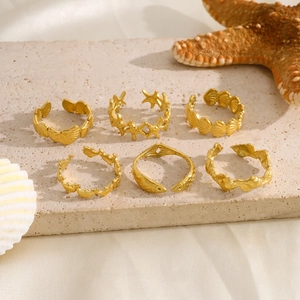 Detailed close-up of 6-piece gold ocean themed rings with starfish and shell designs