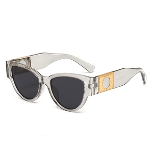 Oval cat-eye sunglasses in transparent grey with gold accents and dark grey lenses