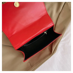 Interior detail of red faux leather bag featuring a gold magnetic clasp and zipper pocket