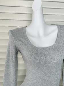 Dettaglio della trama in maglia a coste grigie di una t-shirt a maniche lunghe con scollo a U