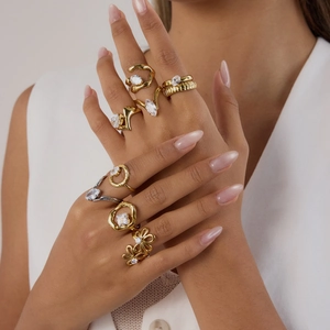 Detailed view of stacked 18K gold and silver rings with zircon stones on model's hand