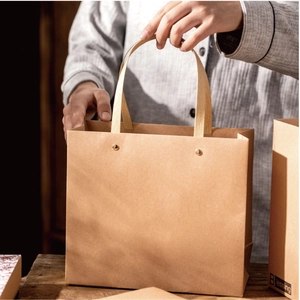 Close-up of durable brown kraft paper bag with flat handles and gold rivet reinforcement