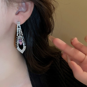 Detail of silver drop earrings with purple marquise gem and sparkling rhinestones