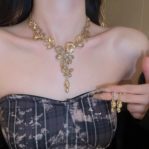 Close-up of champagne crystal drop necklace and earring set on female model neck
