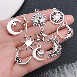 Set of 10 vintage silver alloy sun moon and star charms held in hand for DIY jewelry making