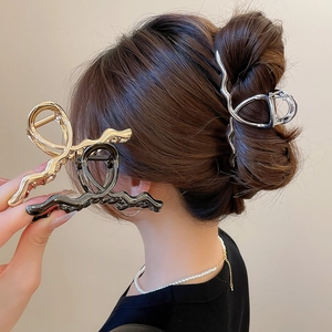 Detailed close-up of metallic wavy hair claws in gold, silver, and black finishes
