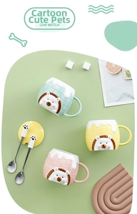 Flat lay detail of pastel ceramic mugs with cute 3D animal relief and paw-shaped spoons