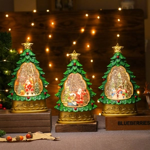 Three green Christmas tree glitter water lanterns with festive figurines on wooden stands