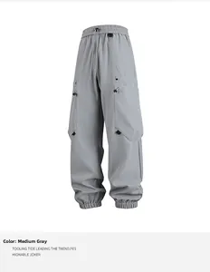 Detalle de pantalones cargo grises con cintura elástica de cordón y bolsillos techwear
