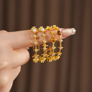 Detail of vintage gold-plated earrings with tiger eye stone, pearls and zircon accents