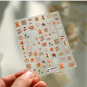 Détail macro de stickers ongles de Noël en relief avec oursons et bonshommes de neige