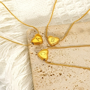 Pendenti a cuore in acciaio dorato con lettere A B C su sfondo in pietra beige