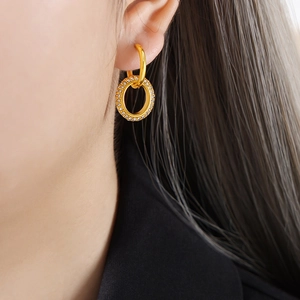 Boucles d'oreilles doubles anneaux dorés avec pavé de zircons sur un mannequin