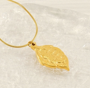 Close-up of golden leaf pendant with embossed texture on a sleek snake chain necklace
