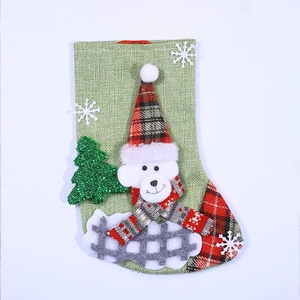 Large green burlap Christmas stocking with plush bear and plaid details for holiday decor