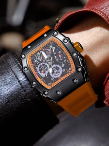 Detalle de reloj mecánico esqueleto de forma de tonel con correa de silicona naranja