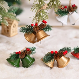 Close-up of Christmas bell ornaments with pine cones and berries on snowy background
